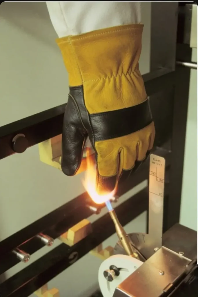 EN 407 safety standard laboratory test applying a direct gas burner flame to Arasweld leather welding glove to measure limited flame spread.